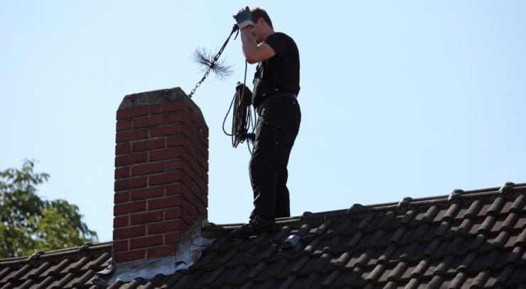 Chimney sweep inserting a brush