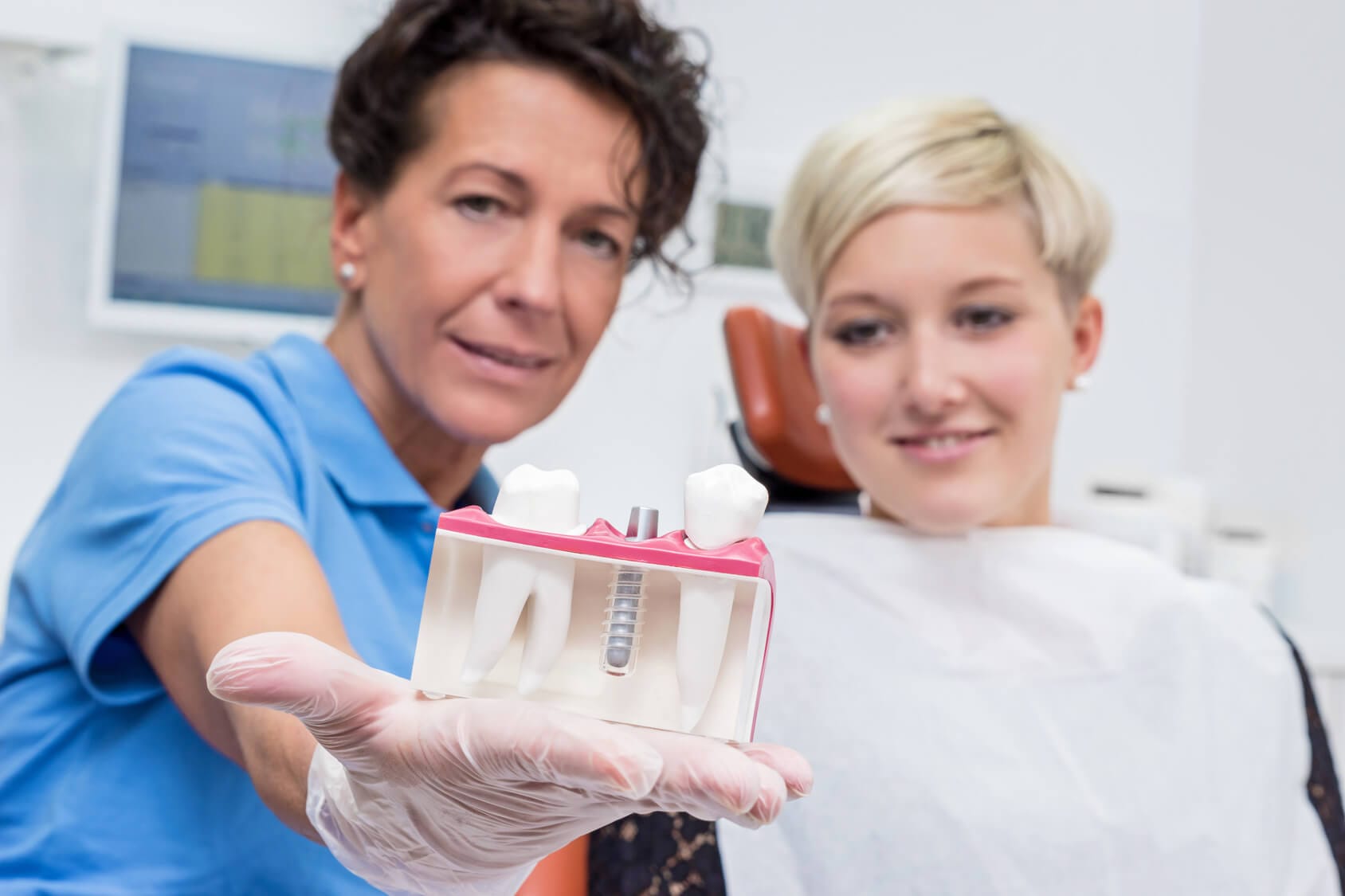 Zahn&auml;rztin bespricht mit Patientin ein Implantat